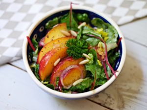 Marinierte Pfirsiche auf grünem Salat